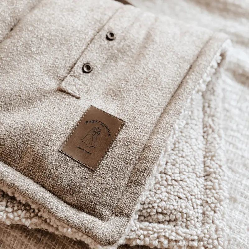 Zwijana mata podróżna dla psa z poręcznymi uchwytami do łatwego transportu.